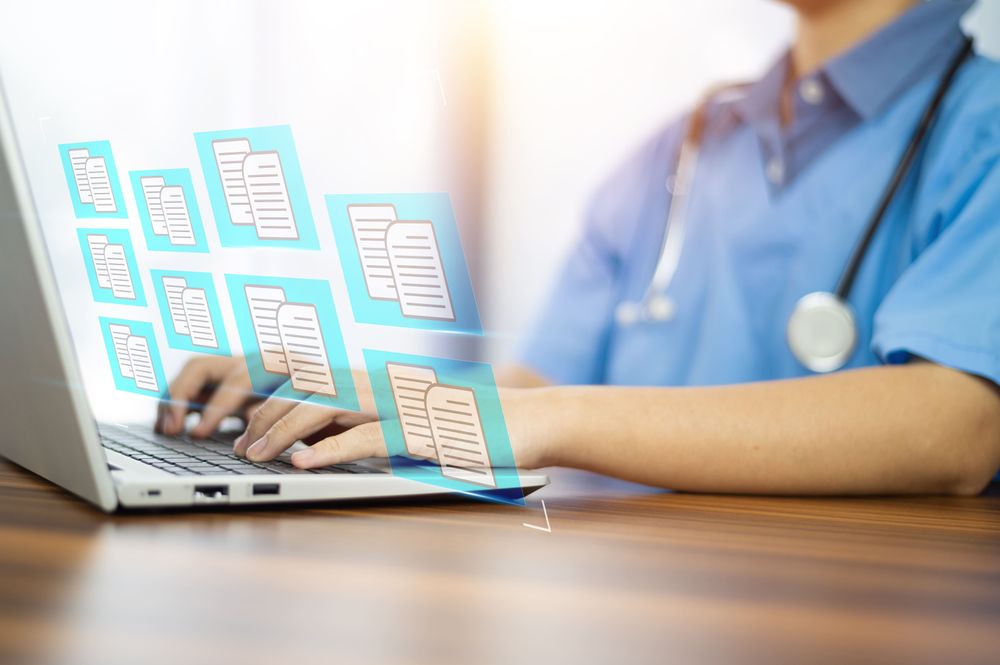 Medical summarization specialist reviewing patient records on computer